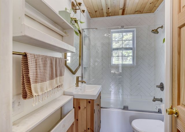 a bathroom with a sink toilet a mirror and shower