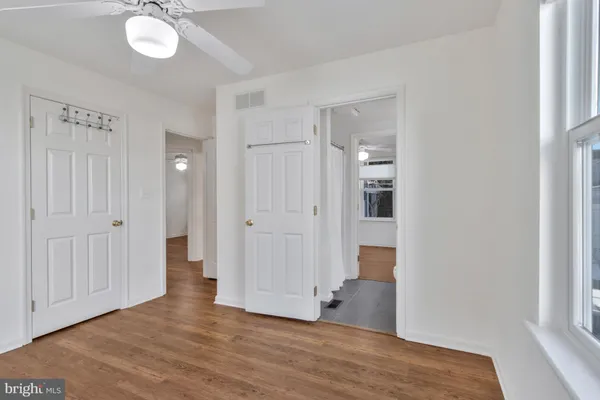 an empty room with wooden floor and windows