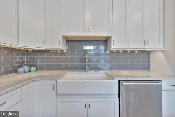 a kitchen with granite countertop white cabinets and stainless steel appliances