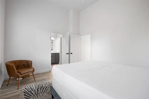 a spacious bedroom with a bed and chair