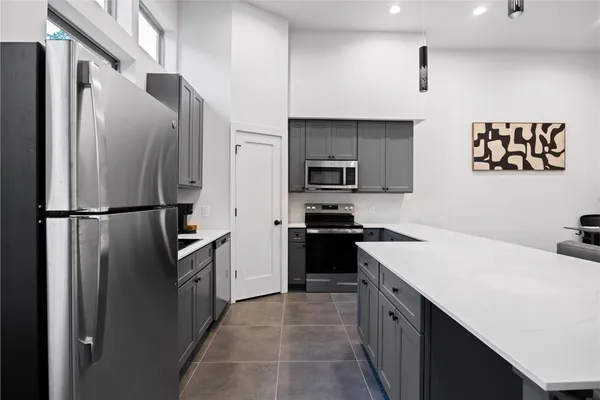 a kitchen with stainless steel appliances a refrigerator stove microwave and sink