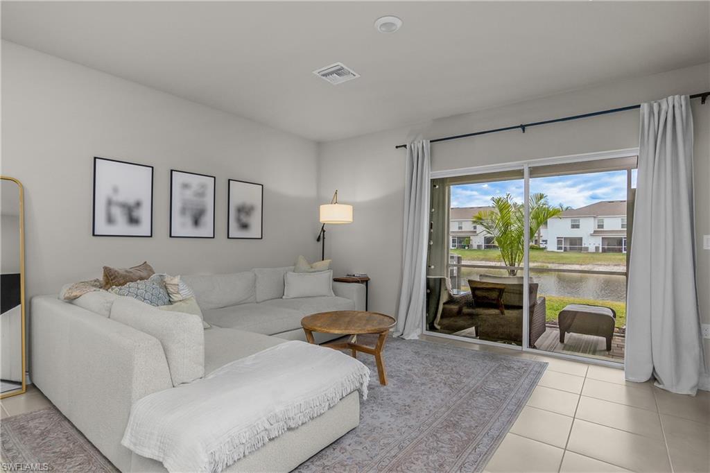 15436 Wildflower Circle Naples, FL 34119 - Photo 16 of 42 Living room featuring light tile patterned flooring and a water view