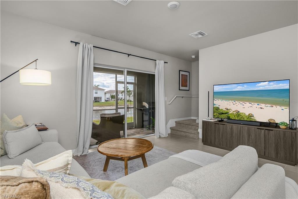 15436 Wildflower Circle Naples, FL 34119 - Photo 17 of 42 Living room featuring stairs and light tile patterned flooring