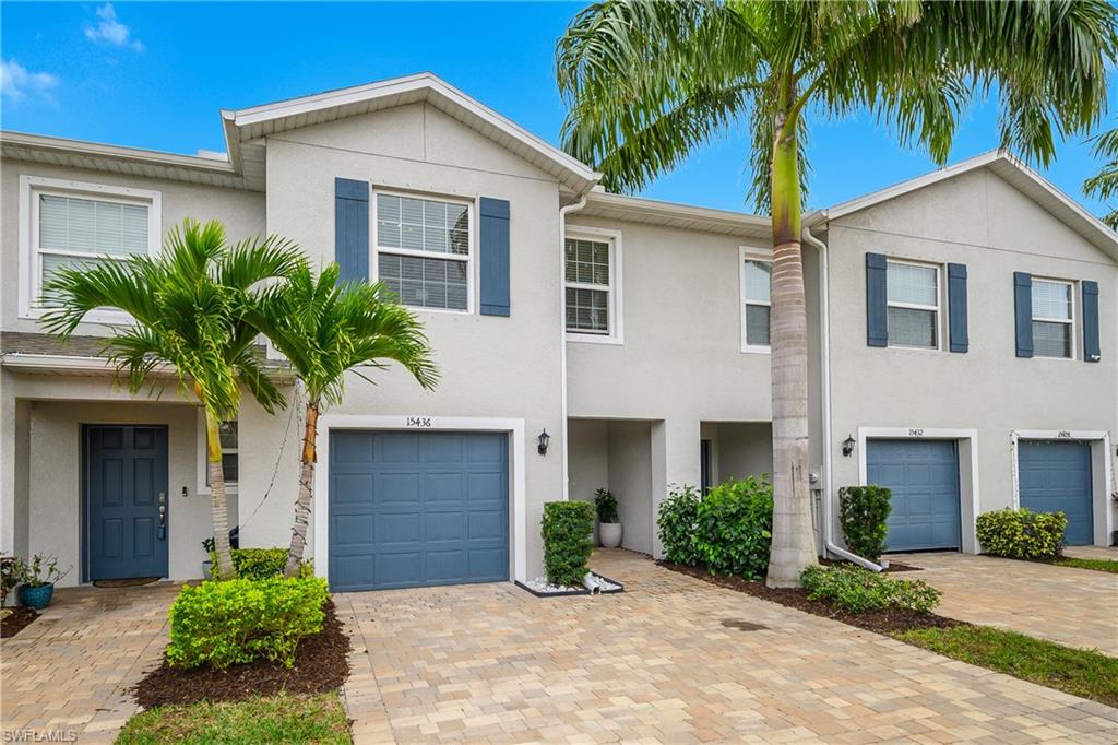 15436 Wildflower Circle Naples, FL 34119 - Photo 2 of 42 Traditional-style house with stucco siding, decorative driveway, and an attached garage
