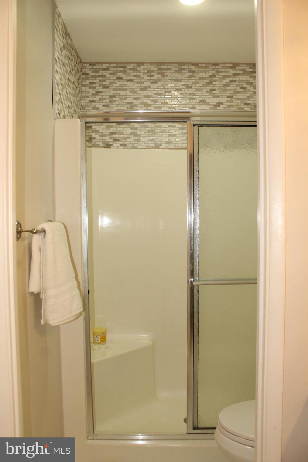 15002 Eardley Court, Unit 282B Silver Spring, MD 20906 - Photo 16 of 28 a bathroom with a granite countertop shower and a toilet
