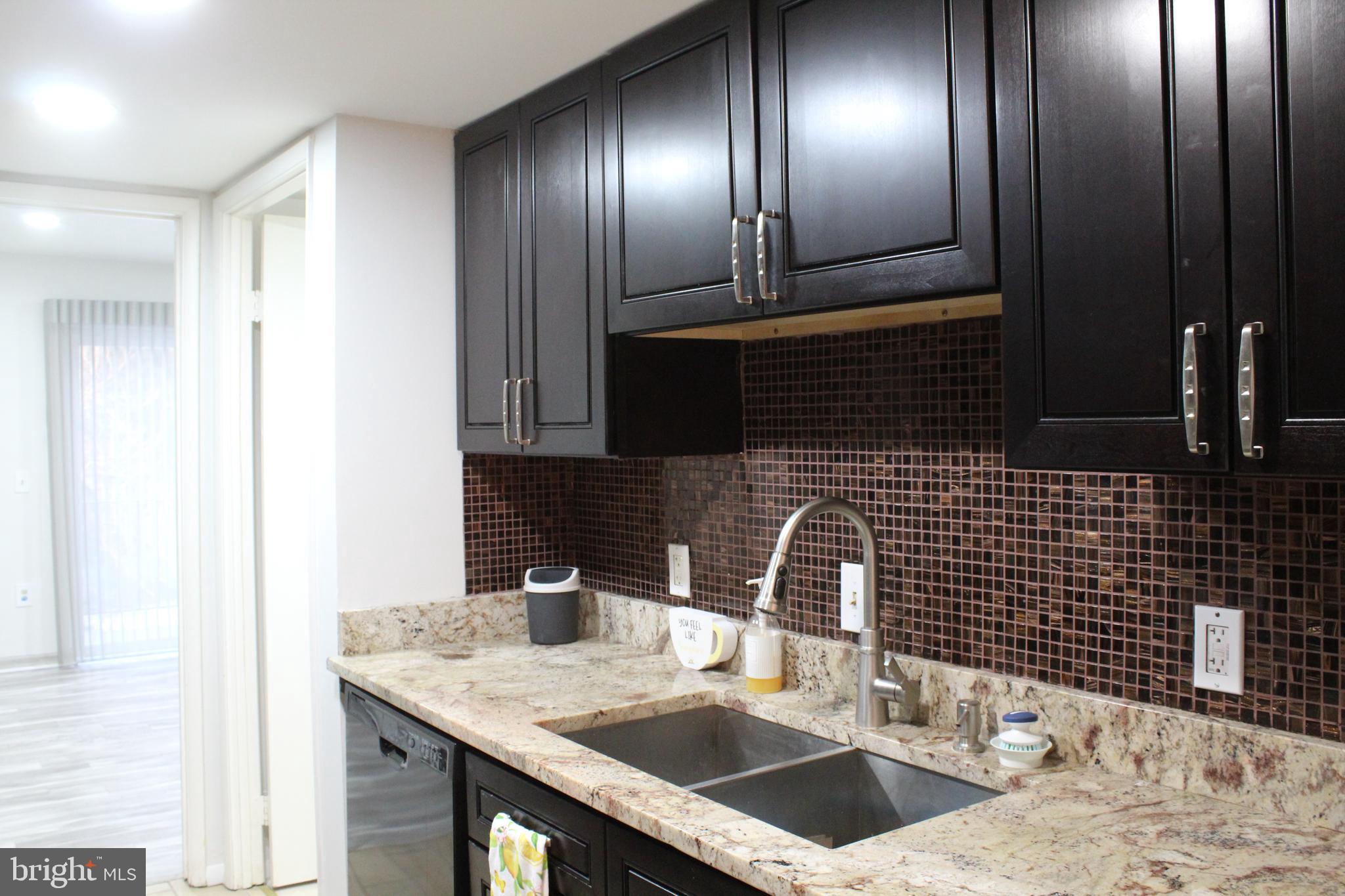15002 Eardley Court, Unit 282B Silver Spring, MD 20906 - Photo 2 of 28 a kitchen with granite countertop stainless steel appliances a sink and a wooden cabinets