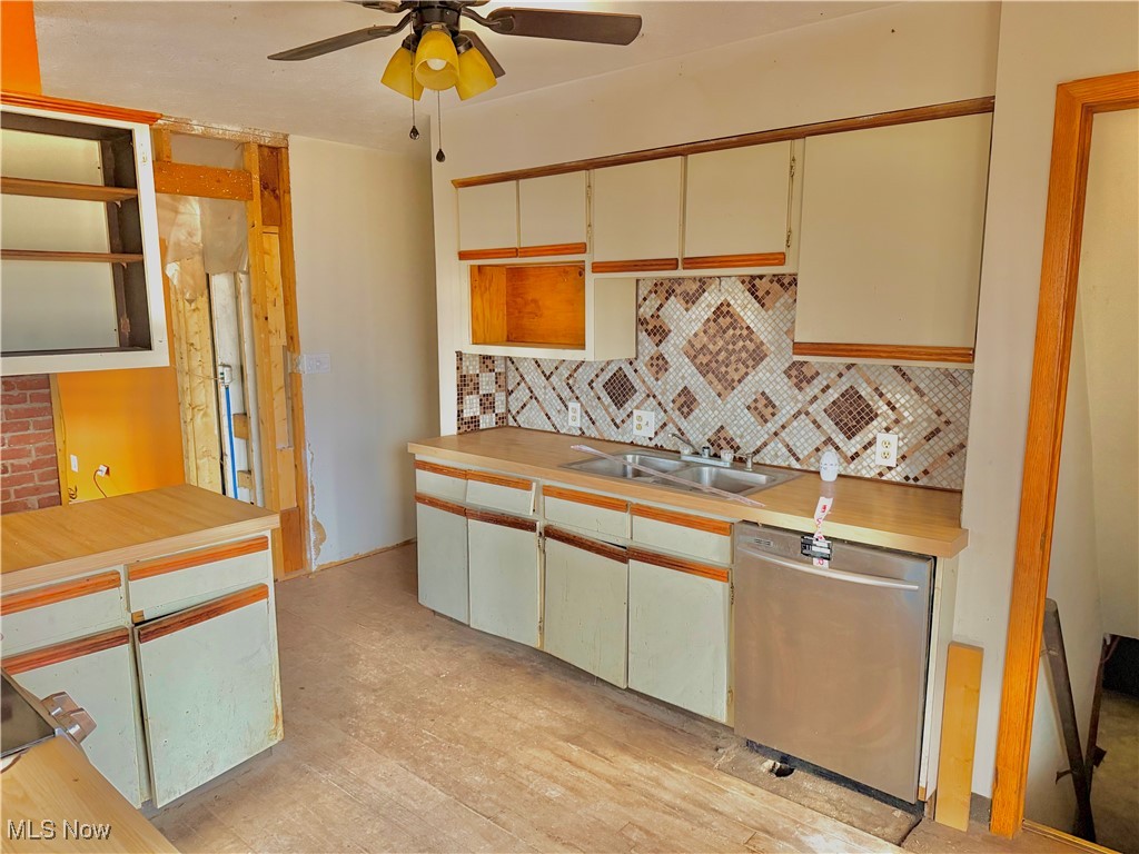 2898 Canton Road Uniontown, OH 44685 - Photo 12 of 20 Kitchen with light countertops, stainless steel dishwasher, open shelves, backsplash, and ceiling fan