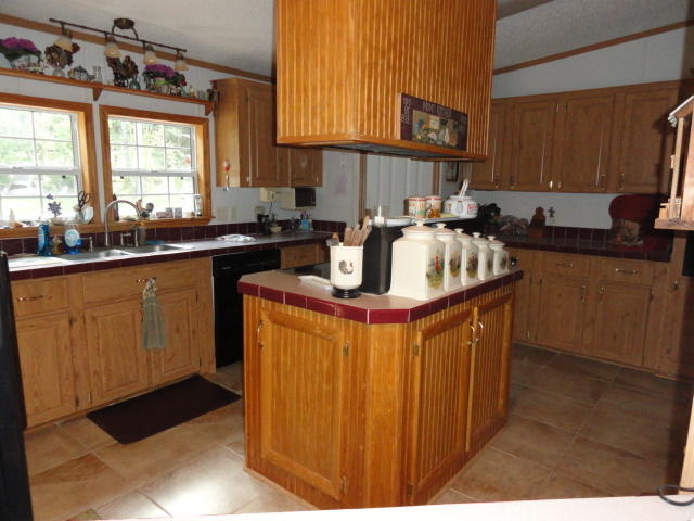 2592 Hinote Road DeFuniak Springs, FL 32433 - Photo 6 of 46 a kitchen with kitchen island granite countertop a sink stove and cabinets
