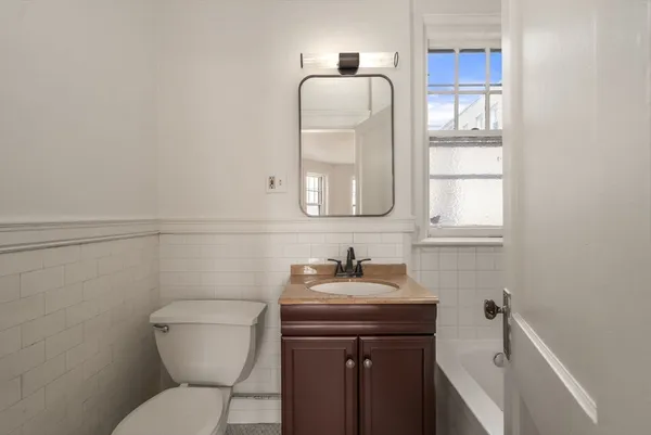 a bathroom with a toilet sink and mirror