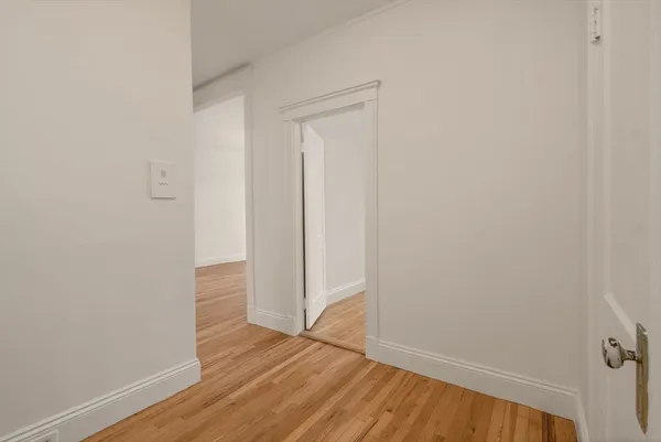 a view of an empty room with wooden floor