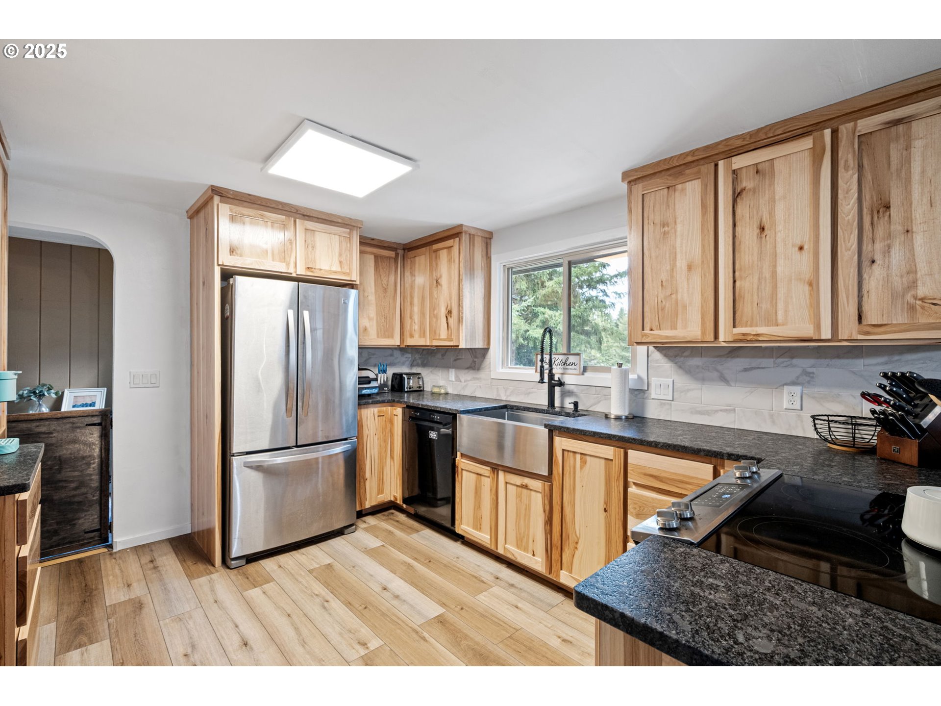 130 Tioga Court Cottage Grove, OR 97424 - Photo 29 of 44 a kitchen with stainless steel appliances granite countertop a refrigerator a sink dishwasher and wooden cabinets with wooden floor