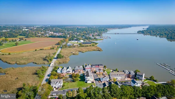 an aerial view of lake and residential houses with outdoor space