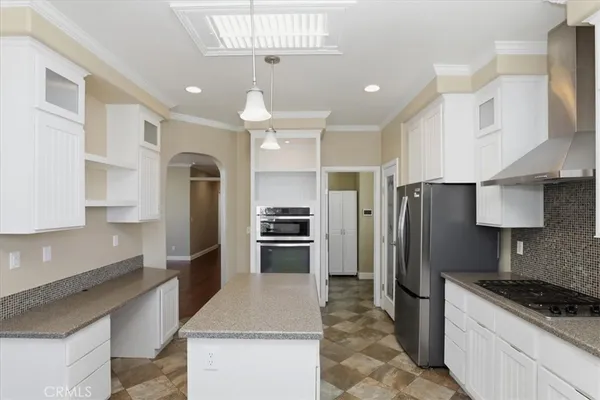a kitchen with stainless steel appliances granite countertop a refrigerator a stove a sink and a refrigerator