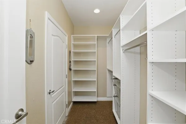 a view of walk in closet with empty racks