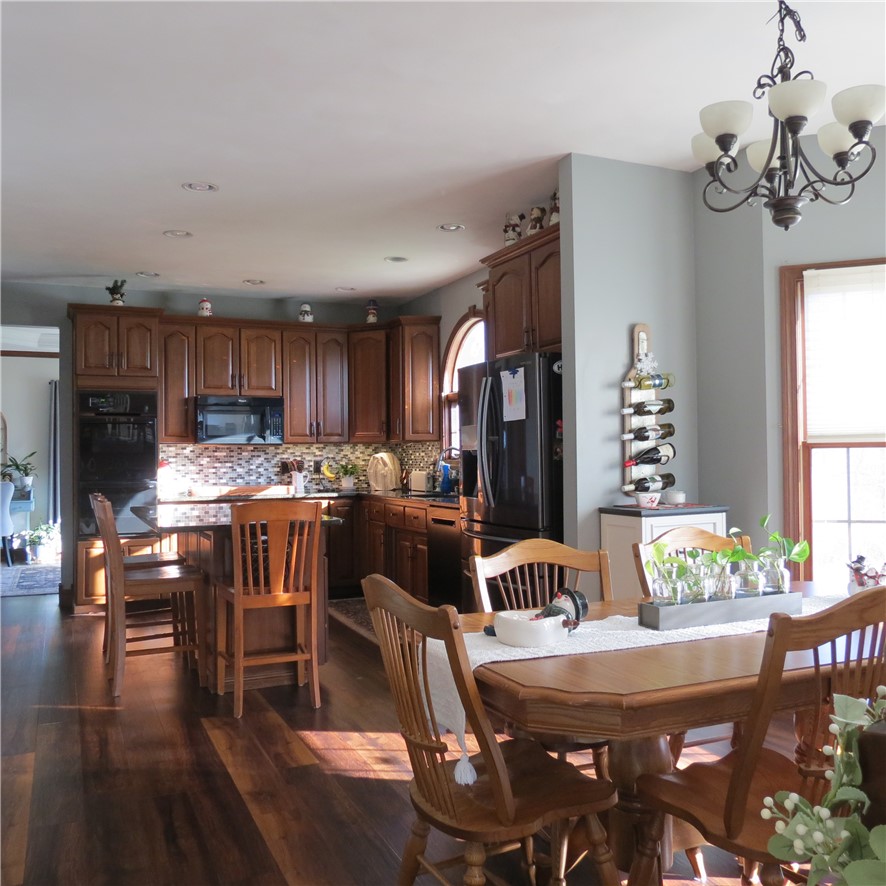 10160 Lochard Road Sidney, OH 45365 - Photo 15 of 41 This spacious kitchen and dining area features rich wood flooring and abundant natural light.