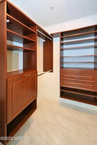 a view of walk in closet with empty racks
