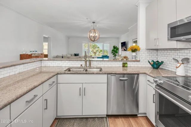 a kitchen with white cabinets and stainless steel appliances