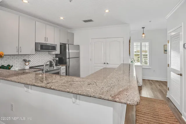 a kitchen with stainless steel appliances granite countertop a sink refrigerator and cabinets