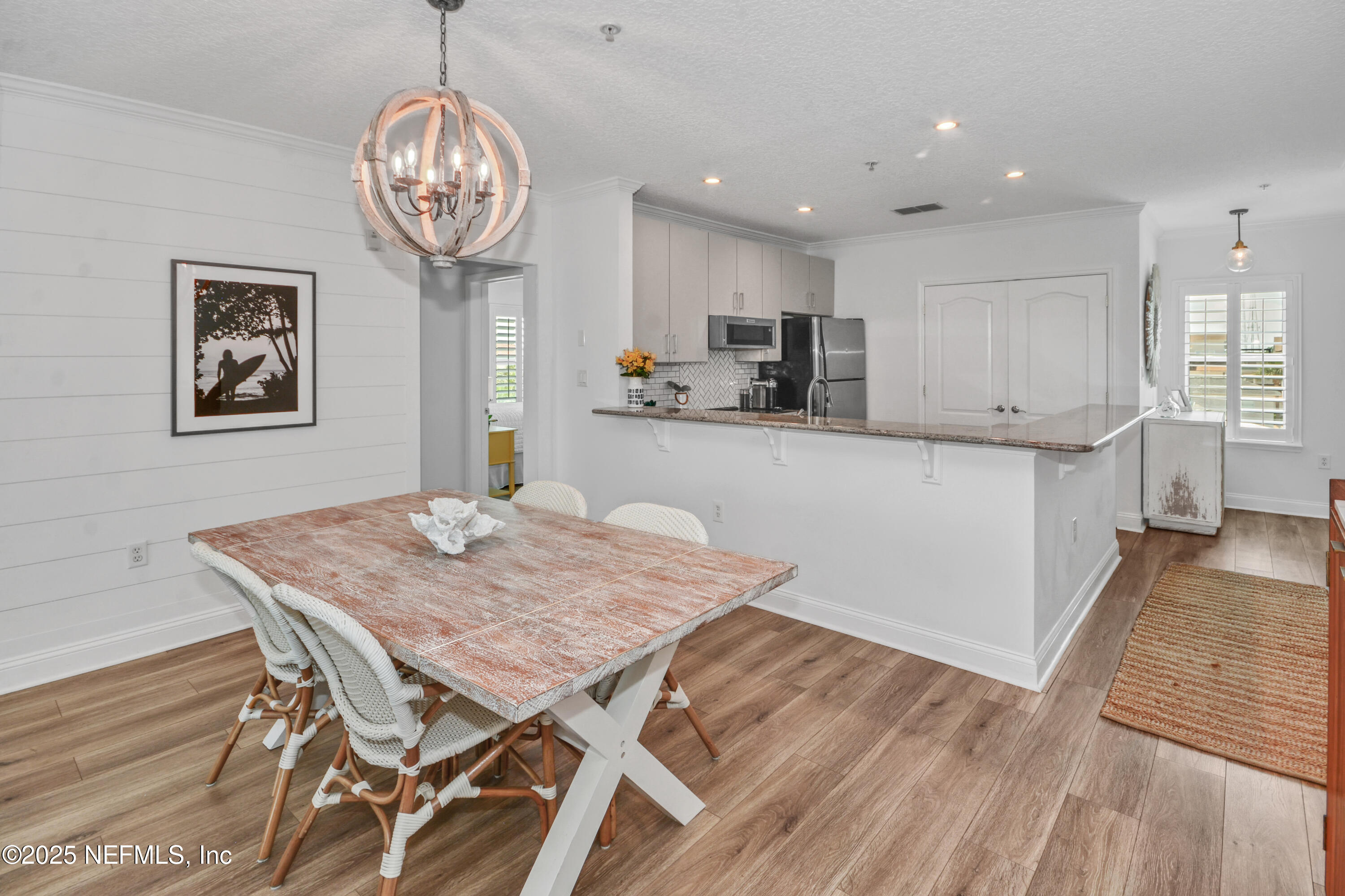 922 1st Street South, Unit 302 Jacksonville Beach, FL 32250 - Photo 9 of 28 a view of a dining room with furniture wooden floor and chandelier