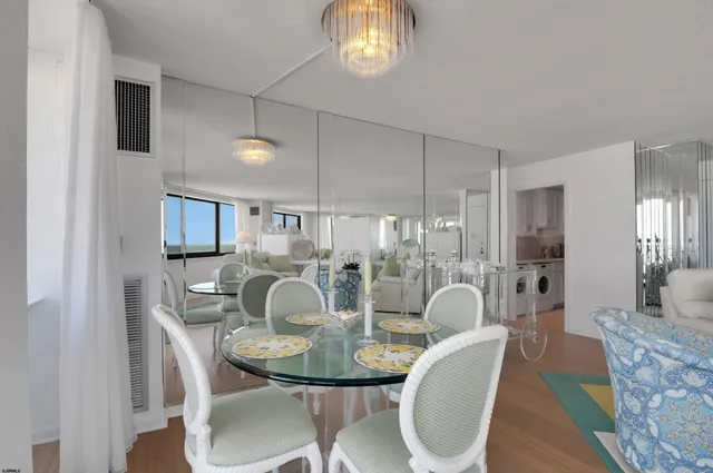 a dining room with furniture a chandelier and wooden floor