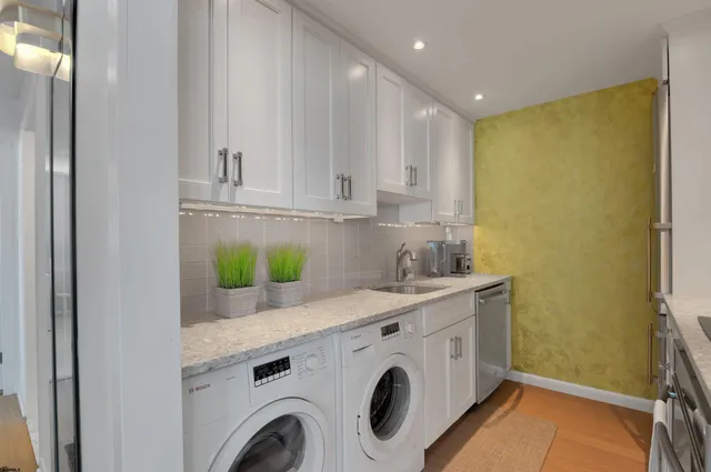 a utility room with cabinets washer and dryer