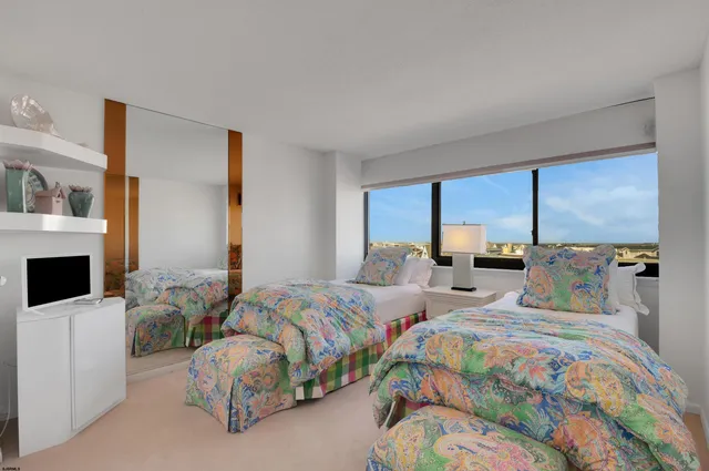 a bedroom with two beds and a large window