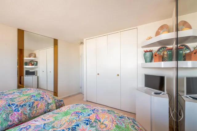 a bedroom with a bed a lamp and a closet