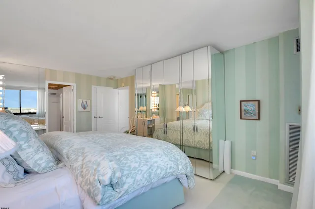 a bedroom with a large bed and a chandelier