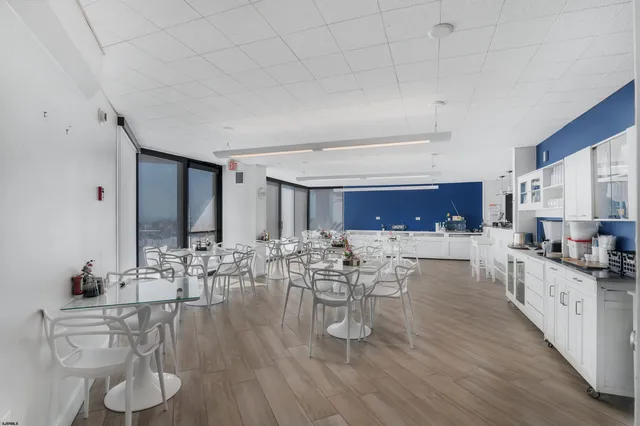 a living room with furniture a large window and wooden floor