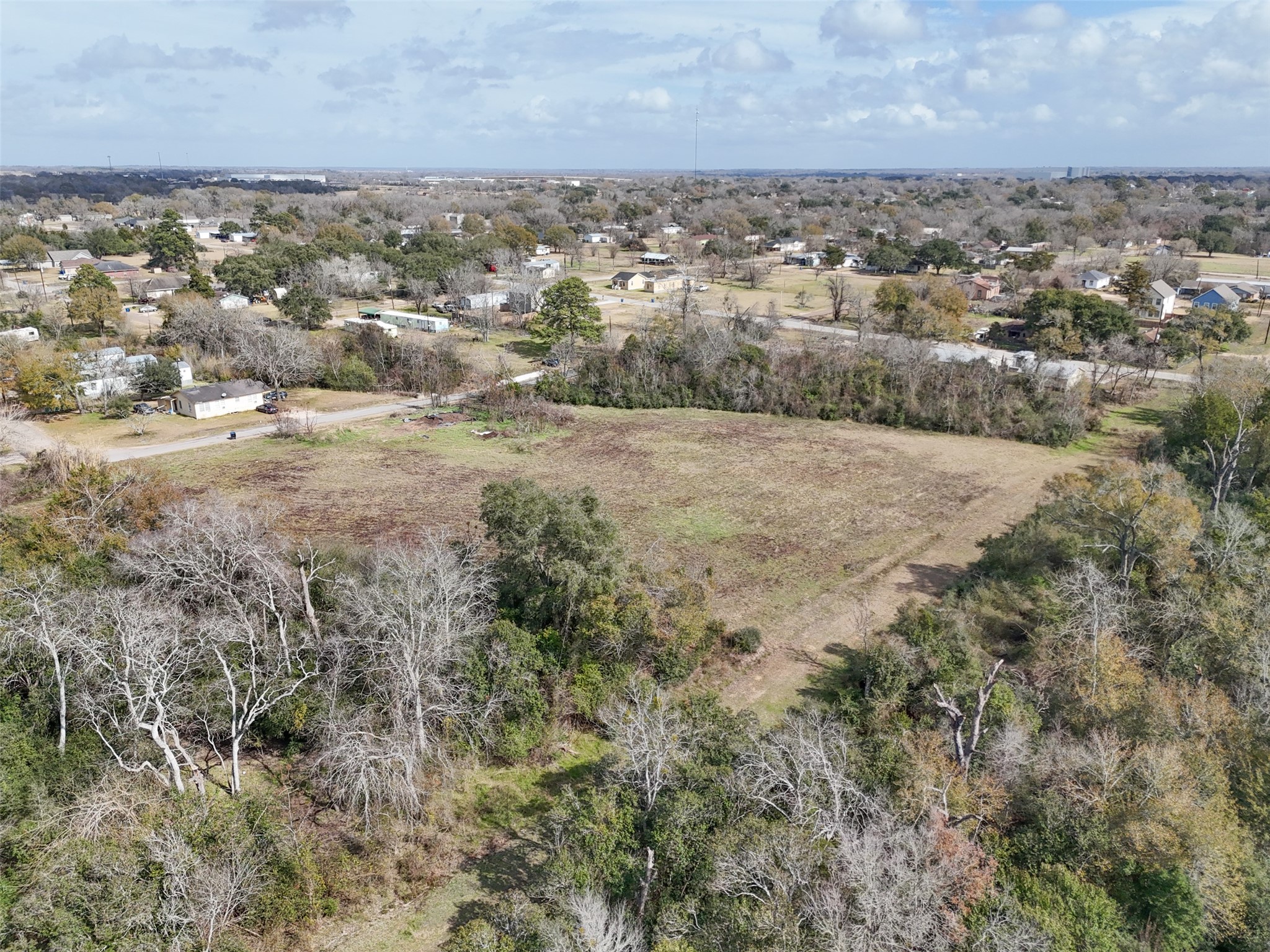 Tbd Tbd 22nd Hempstead, TX 77445 - Photo 13 of 20 Wide overhead view capturing the balance of open land and surrounding greenery, with nearby residential streets visible for context.