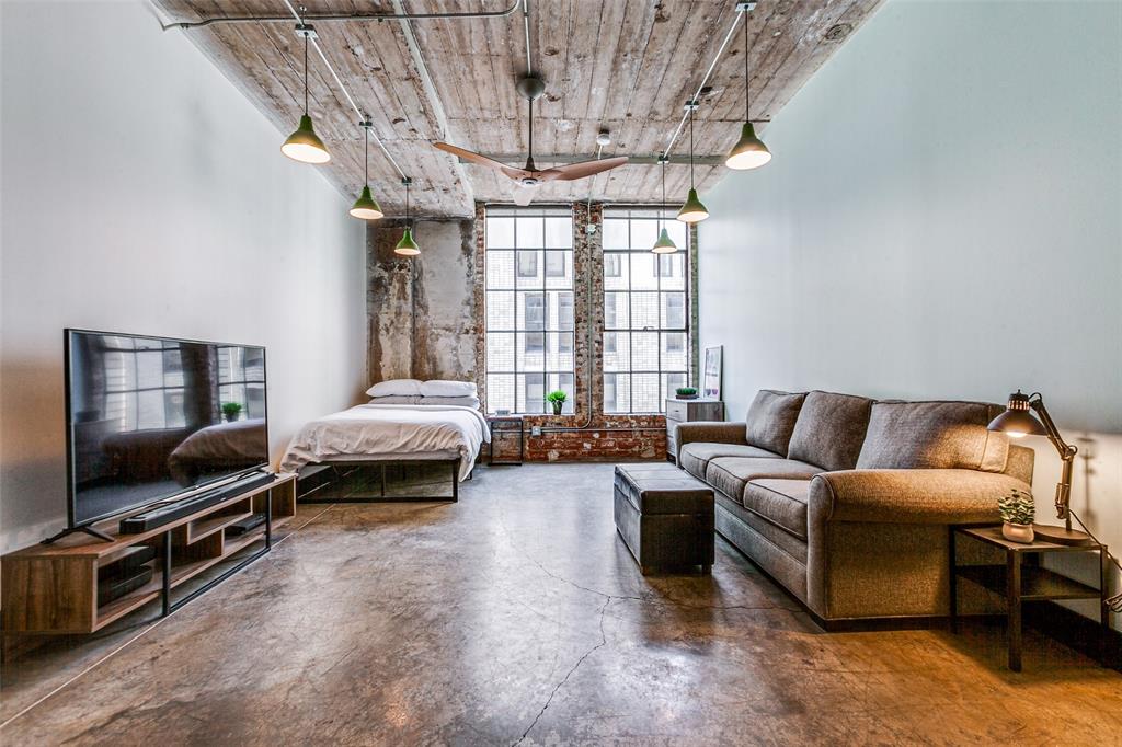 1122 Jackson Street, Unit 917 Dallas, TX 75202 - Photo 2 of 21 a living room with furniture a flat screen tv and a window