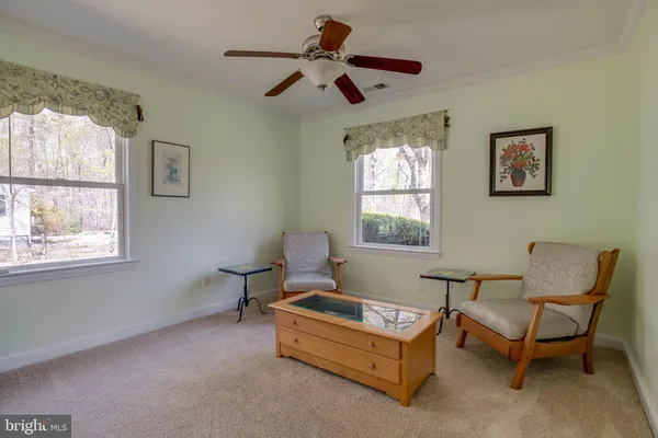 a view of a house with large trees and wooden fence