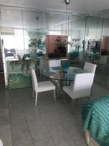 a dining room with furniture and a floor to ceiling window