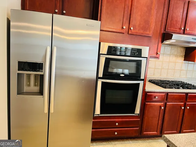 a kitchen with granite countertop cabinets and steel stainless steel appliances