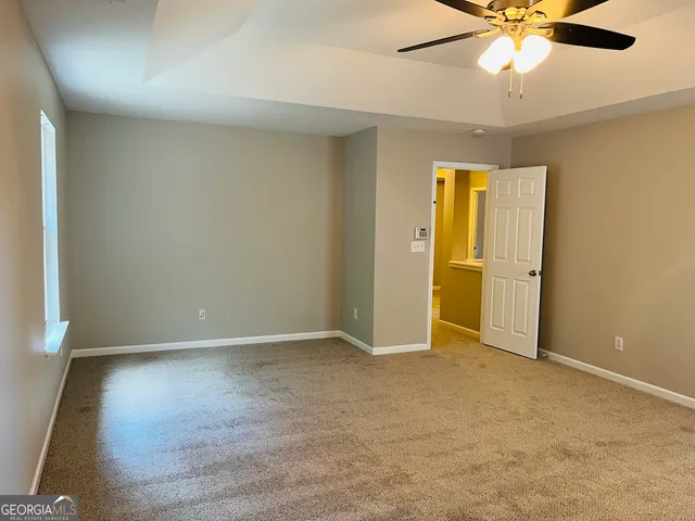 an empty room with closet and a chandelier fan