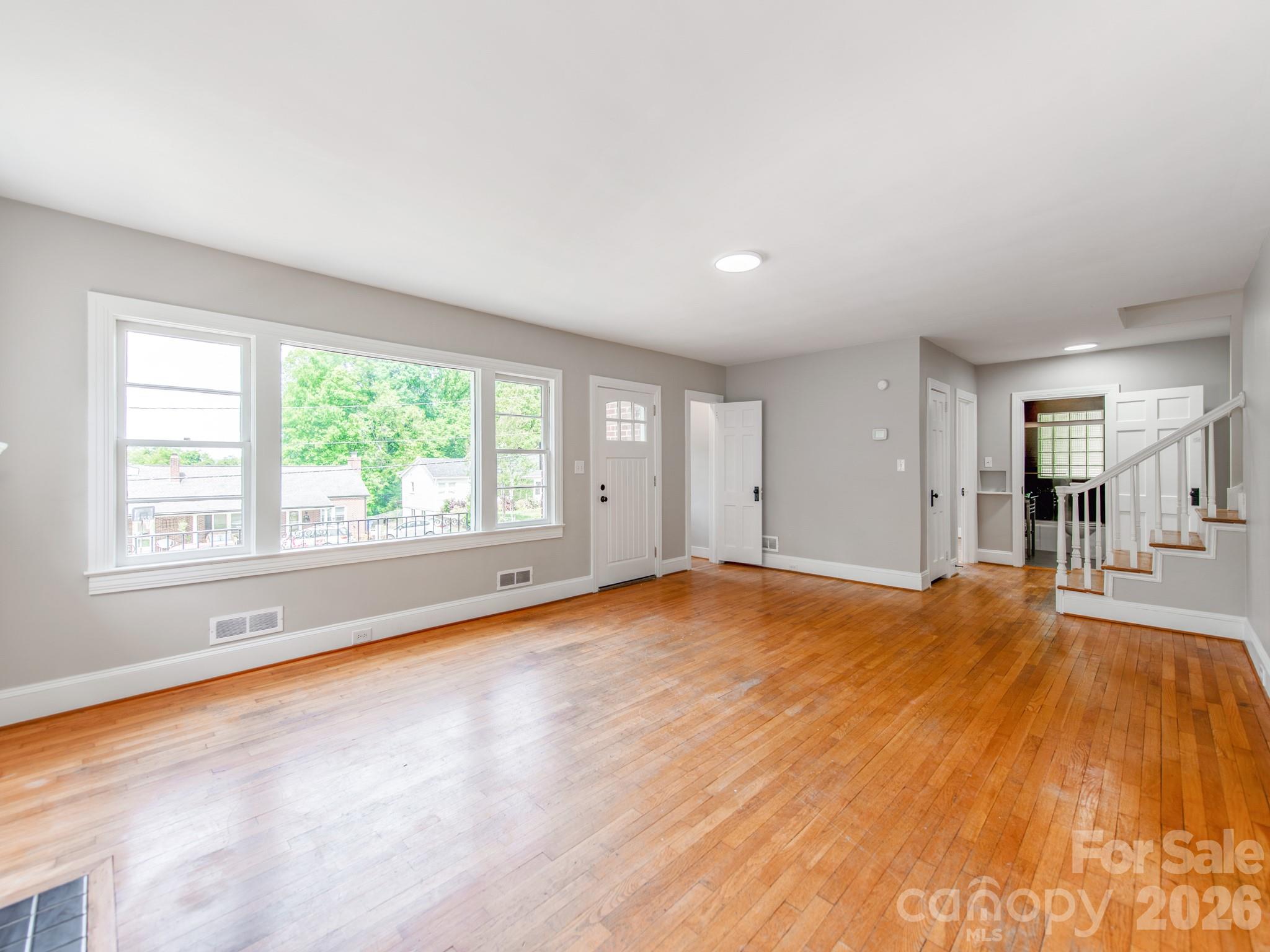 113 Falls Street Morganton, NC 28655 - Photo 6 of 33 an empty room with wooden floor and windows