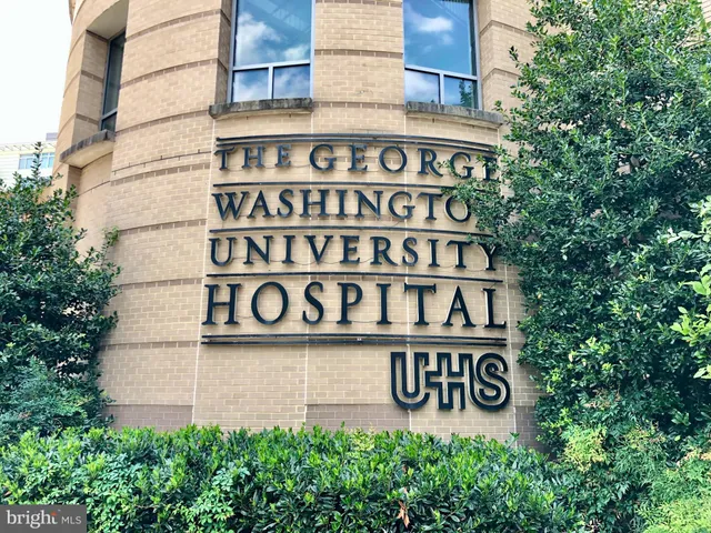 a view of a brick house with a large trees