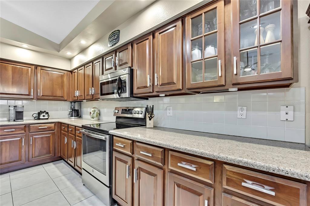 488 Fort Mill Lane Spring Hill, FL 34609 - Photo 15 of 54 a kitchen with stainless steel appliances granite countertop a refrigerator and cabinets