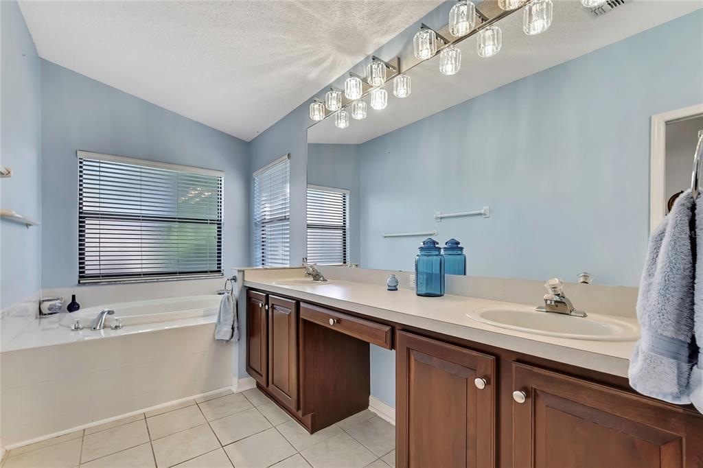 488 Fort Mill Lane Spring Hill, FL 34609 - Photo 20 of 54 a bathroom with a granite countertop sink a large mirror and bathtub