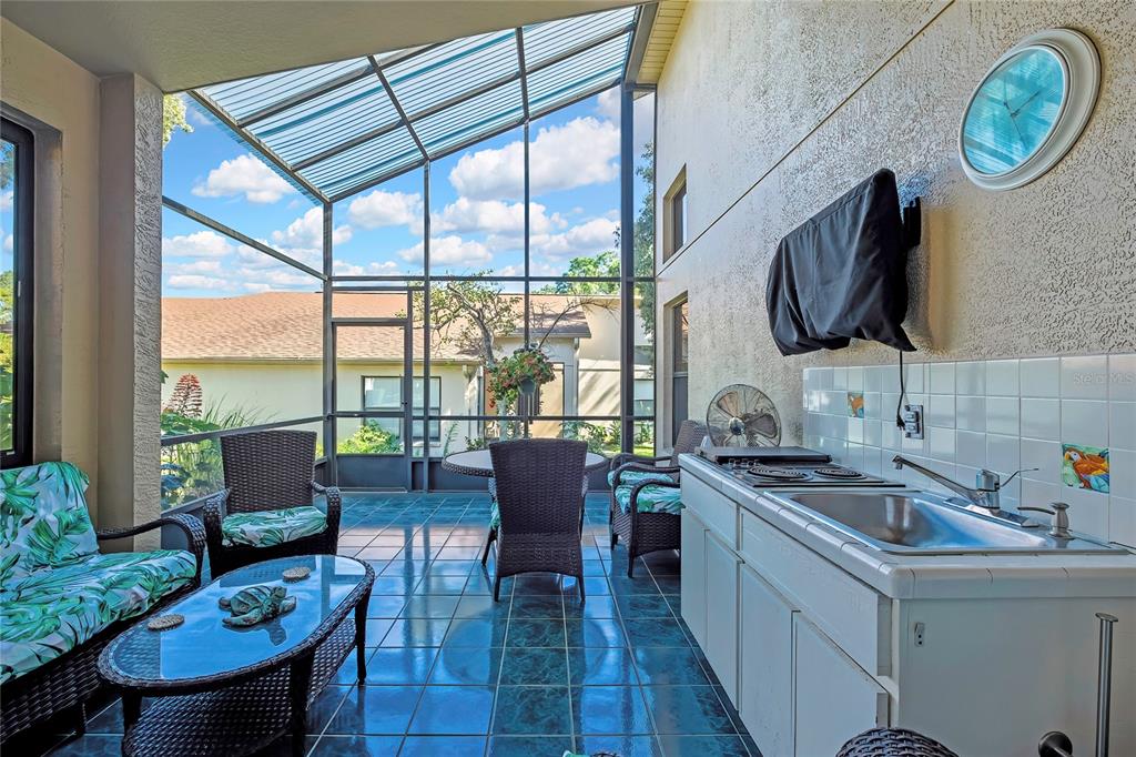 488 Fort Mill Lane Spring Hill, FL 34609 - Photo 29 of 54 a kitchen with a stove a sink and a dining table with garden view
