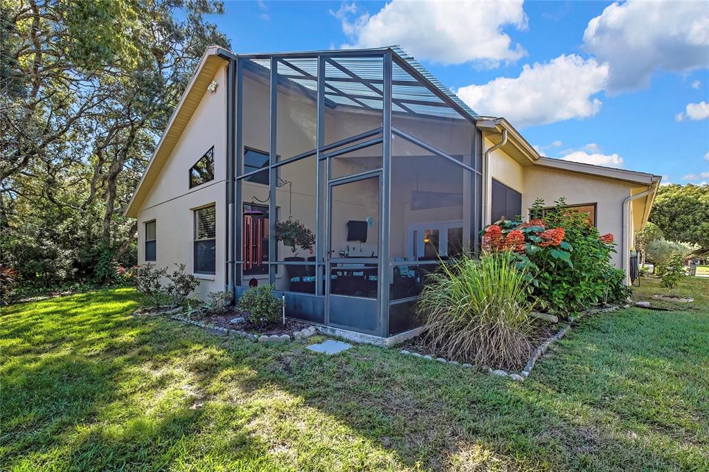 488 Fort Mill Lane Spring Hill, FL 34609 - Photo 33 of 54 a view of a house with brick walls and a yard with plants