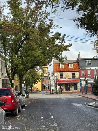 a front view of a building with lot of cars and trees