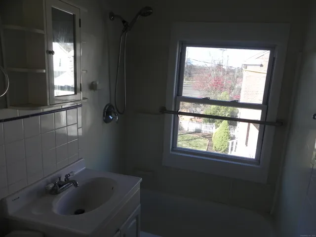 a bathroom with a sink window and mirror