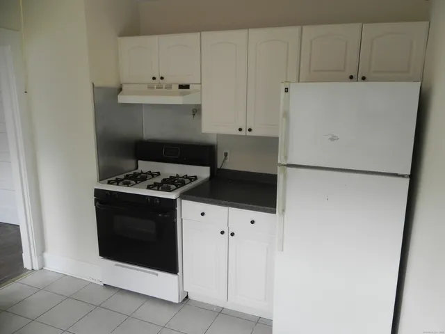 a kitchen with white cabinets and white appliances