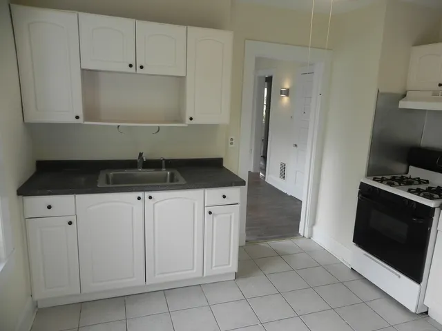 a kitchen with granite countertop white cabinets and black appliances