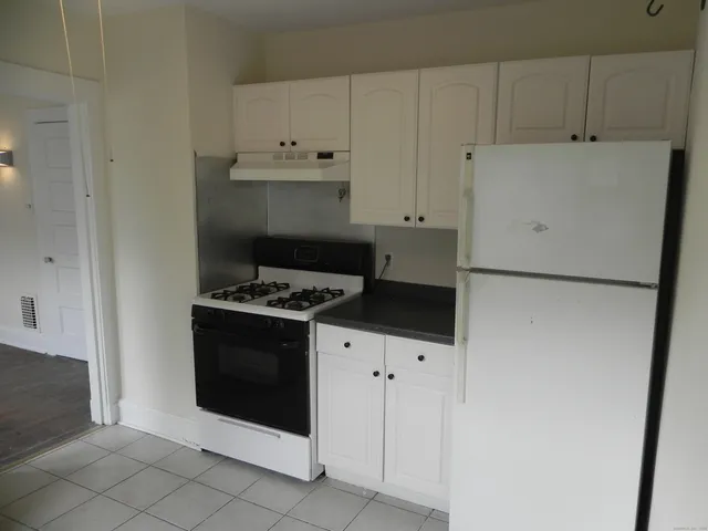 a kitchen with white cabinets and white appliances