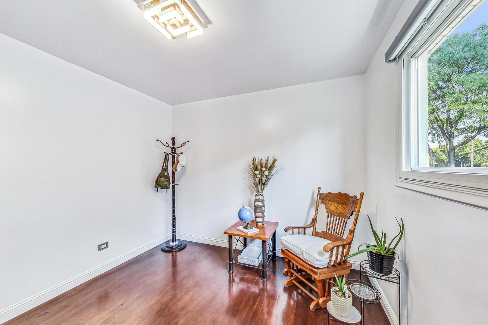 921 Crockett Avenue Addison, IL 60101 - Photo 18 of 34 a view of a room with wooden floor and lounge chairs