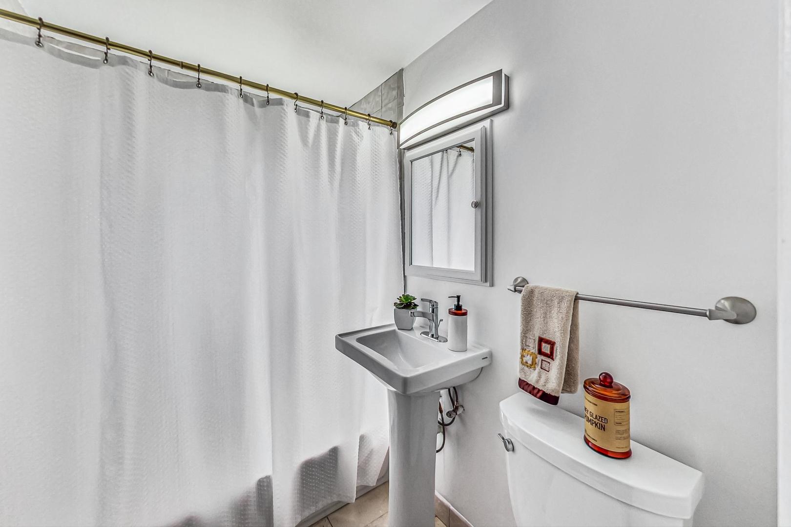 921 Crockett Avenue Addison, IL 60101 - Photo 19 of 34 a bathroom with a sink a mirror and shower curtain