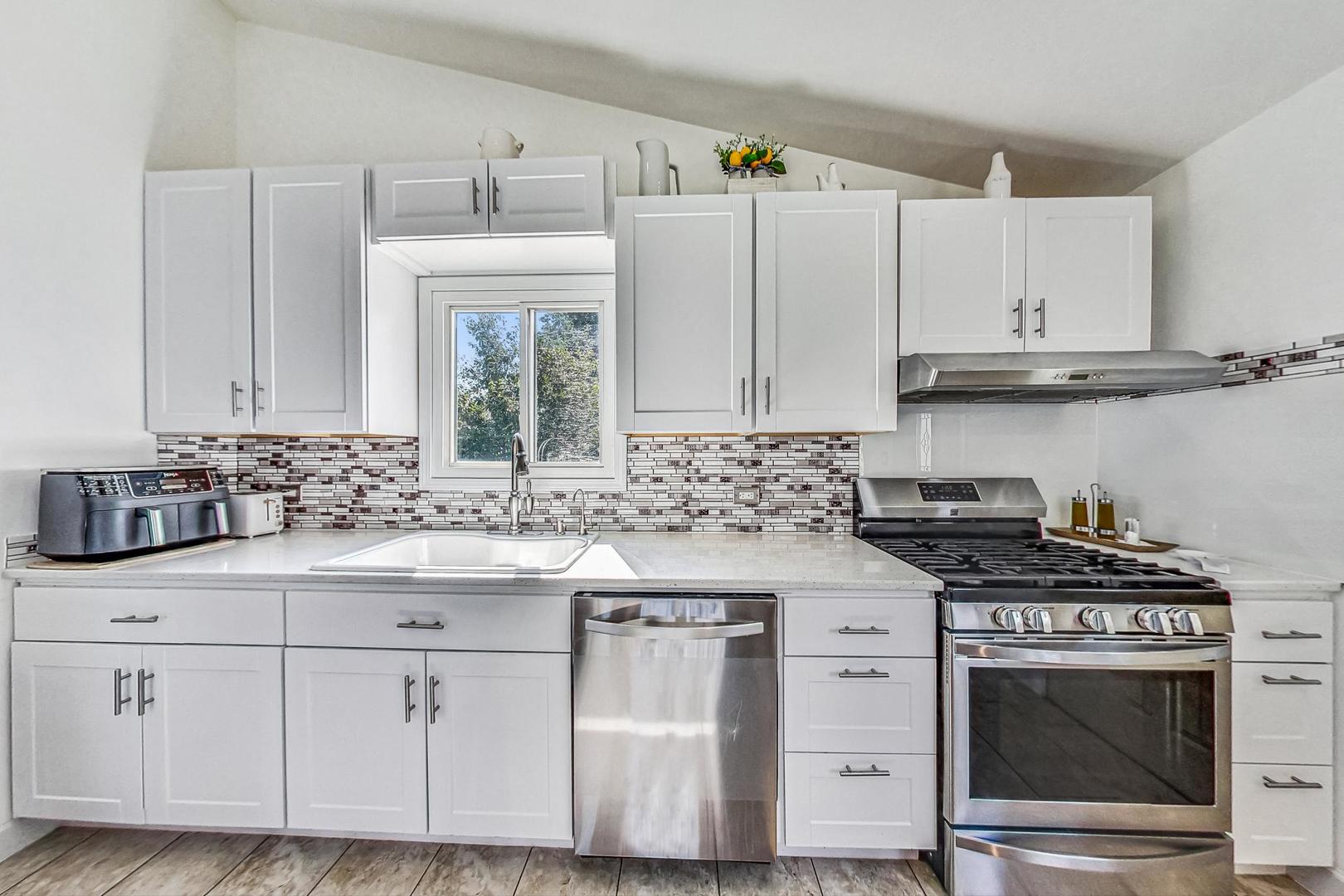 921 Crockett Avenue Addison, IL 60101 - Photo 10 of 34 a kitchen with white cabinets and appliances