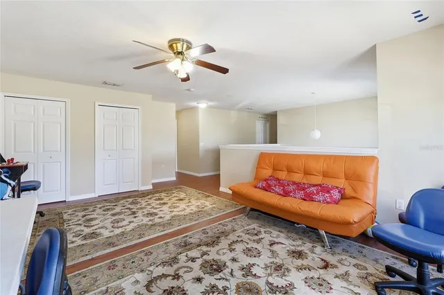 a spacious bedroom with a bed and a ceiling fan